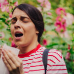 Μία κοπέλα στην εξοχή φτερνίζεται.