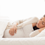 Μία έγκυος που κοιμάται στο πλάι.